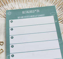 Lade das Bild in den Galerie-Viewer, Was habe ich diese Woche gut gemacht? Deine Erfolge können im Erfolgstagebuch Alltagsheldin in Form eines Blocks im Format A5 festgehalten werden. In der Nahaufnahme sieht man das minimalistische petrolfarbene Design mit Elemententen Sternen Mond und Wolken