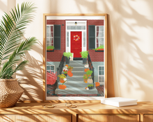 Lade das Bild in den Galerie-Viewer, Poster auf einer Kommode: Das Poster zeigt einen für Herbst oder Halloween geschmückten einladenden Hauseingang.