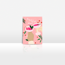 Lade das Bild in den Galerie-Viewer, moderne Weihnachtskarte in angesagter Farbkombination aus rosa und rot mit Abbildung von zwei Händen mit Gläsern mit weihnachtlicher Dekoration und englischen Spruch and have a cup of cheer