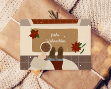 Lade das Bild in den Galerie-Viewer, schöne Weihnachtskarte auf einem Weihnachtsgeschenk mit Frau mit einer Tasse Kaffee in der Hand auf einer Türmatte eines festlich dekorierten Hauseingangs mit Schriftzug frohe Weihnachten