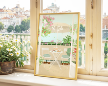 Lade das Bild in den Galerie-Viewer, moderner Print mit Balkon, auf dem viele bunte Blumen vor blauem Himmel sowie ein gedeckter Frühstickstisch mit Croissant und Obst zu sehen sind
