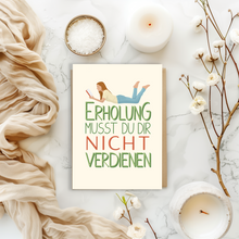 Lade das Bild in den Galerie-Viewer, moderne Grußkarte mit Lettering Spruch Erholung musst du dir nicht verdienen in einem Boho Flatlay
