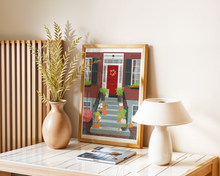 Lade das Bild in den Galerie-Viewer, Tischdekoration mit modernem Kunstposter. Auf dem Poster ist der Eingang eines Klinkerbaus zu sehen. Auf der Treppe vor dem Haus befinden sich viele herbstliche dekorative Elemente.
