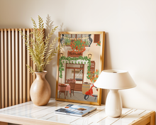 Lade das Bild in den Galerie-Viewer, Moderne Tischdekoration mit Trockenblumen und Poster mit Illustration eines stimmungsvollen italienischen Restaurants in der Toskana. Vor dem Restaurant steht ein Tisch mit zwei Stühlen und einer Pizza und einem Teller Nudeln. Außerdem sind eine rote Vespa und mediteranne Pflanzen zu sehen.
