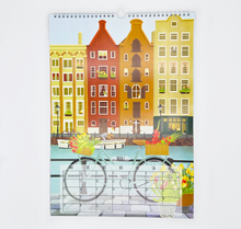 Lade das Bild in den Galerie-Viewer, Der Wandkalender Reisen ist hier mit dem Kalenderblatt ärz 2027 abgebildet. Eie detailreiche Illustration von Amsterdam mit typischem Häusern, Grottenschiff, Fahrrädern und vielen Blumen und floralen Details ist zu erkennen.
