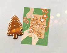 Lade das Bild in den Galerie-Viewer, Weihnachtskarte Plätzchen backen zum Versenden von süßen Weihnachtsgrüßen mit Flatlay Illustration zweier Händepaare, die weihnachtliche Plätzchen verzieren auf grünem Hintergrund
