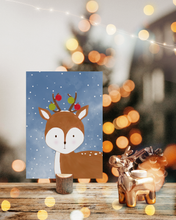 Lade das Bild in den Galerie-Viewer, süße Weihnachtskarte für Kinder mit Illustration eines Rehs im Schnee behangen mit Christbaumkugeln
