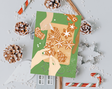 Lade das Bild in den Galerie-Viewer, Postkarte als Gutschein zum Plätzchen backen mit zwei Personen, die gerade Weihnachtsplätzchen verzieren
