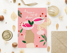 Lade das Bild in den Galerie-Viewer, festliche Weihnachtskarte für Freunde in rosa- und pinktönen mit Illustration zweier Hände, die mit Gläsern anstoßen und passendem Briefumschlag aus Kraftpapier
