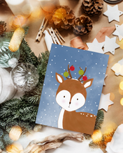 Lade das Bild in den Galerie-Viewer, Weihnachtsgeschenke verpacken mit der weihnachtlichen Postkarte, die ein niedliches Reh im Winter zeigt
